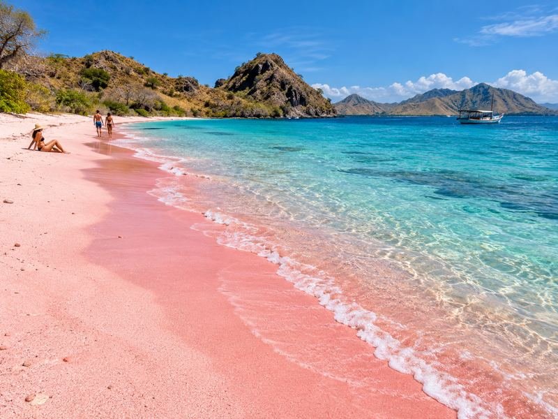Pantai Pink Beach dengan pasir berwarna kemerahan dan perairan jernih