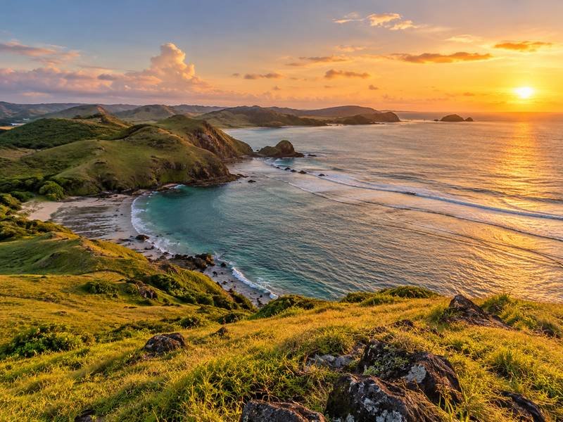 Pemandangan bukit merese lombok dengan hamparan perbukitan dan laut biru dari ketinggian saat sore hari
