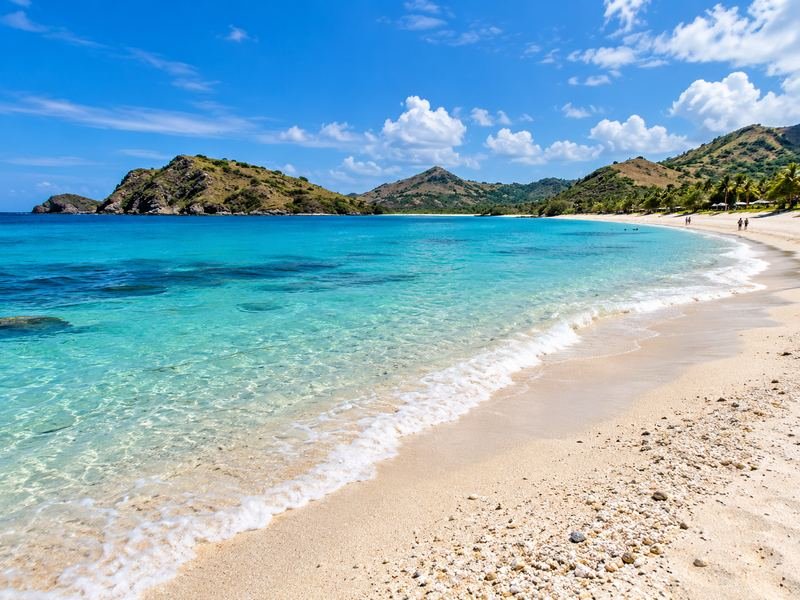 pantai kuta mandalika dengan teluk biru dan bukit hijau